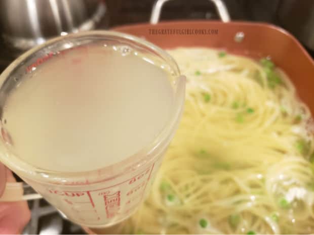 A cup of boiling pasta water is reserved to use later in the dish.