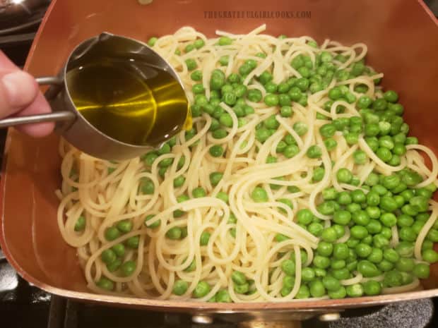 Olive oil, lemon juice and garlic are added to drained pasta and peas.