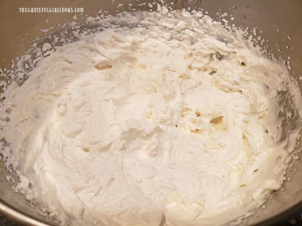 Whipping cream is beaten until it easily forms stiff peaks.