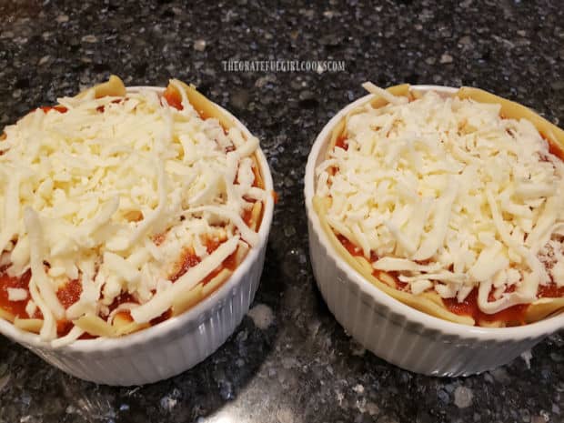 Two mini lasagna bowls, ready for baking in the oven.