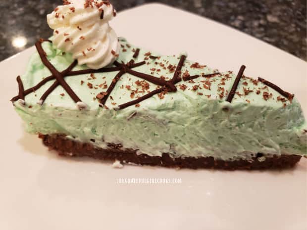 A slice of mint brownie pie, served on a white plate.