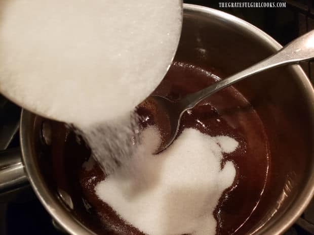 Granulated sugar is added to the melted chocolate and butter in saucepan.