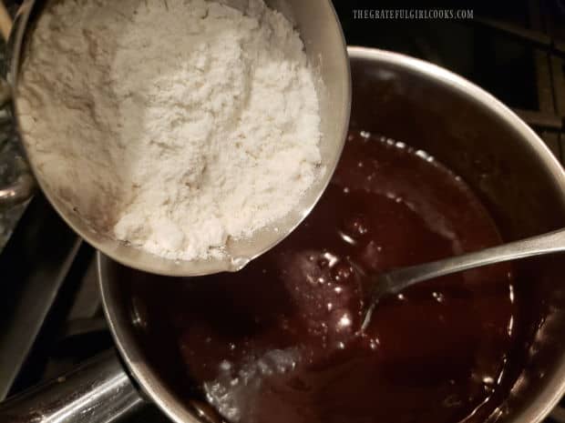 Flour is stirred into the chocolate mixture, a little at a time.