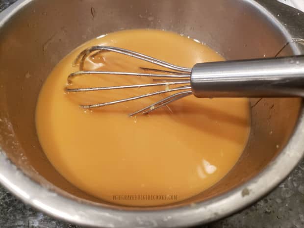 An Asian-inspired orange sauce is whisked and is ready to add to orange cashew chicken.