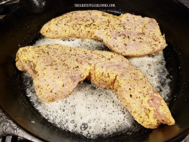 Skillet grilled rockfish fillets are cooked in melted butter in a skillet.