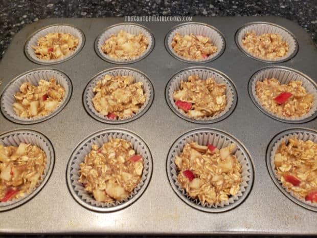 Apple cinnamon baked oatmeal bites batter is evenly divided into paper-lined muffin tins.