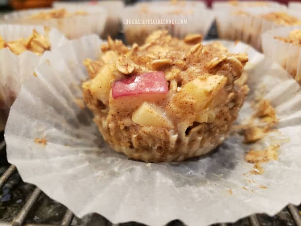 The paper liner pulled away reveals one of the finished apple cinnamon baked apple bites.