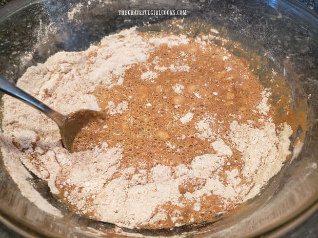 Wet brown bread batter is added to the dry ingredients and stirred, to combine.