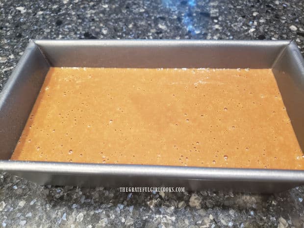 Standard sized loaf pan filled with brown bread batter, and ready to bake.