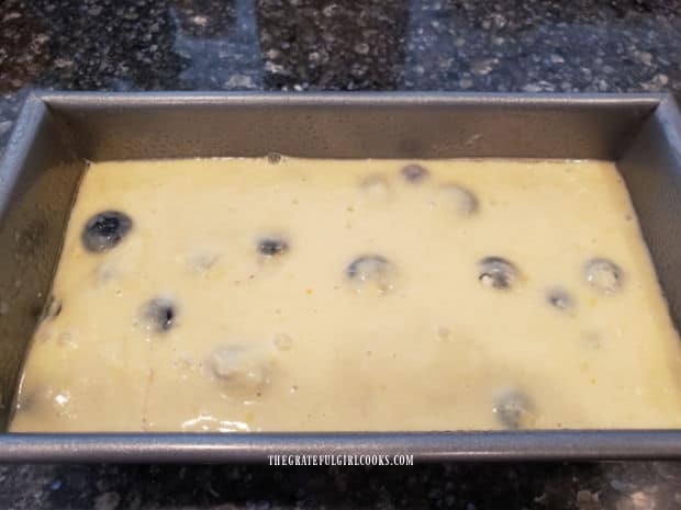 Blueberry breakfast loaf batter in a greased loaf pan, ready for baking.