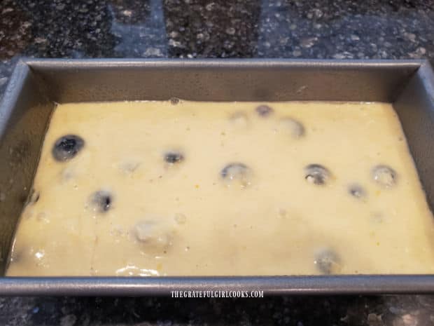 Blueberry breakfast loaf batter in a greased loaf pan, ready for baking.