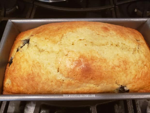 The baked blueberry breakfast loaf is golden brown on top after cooking.