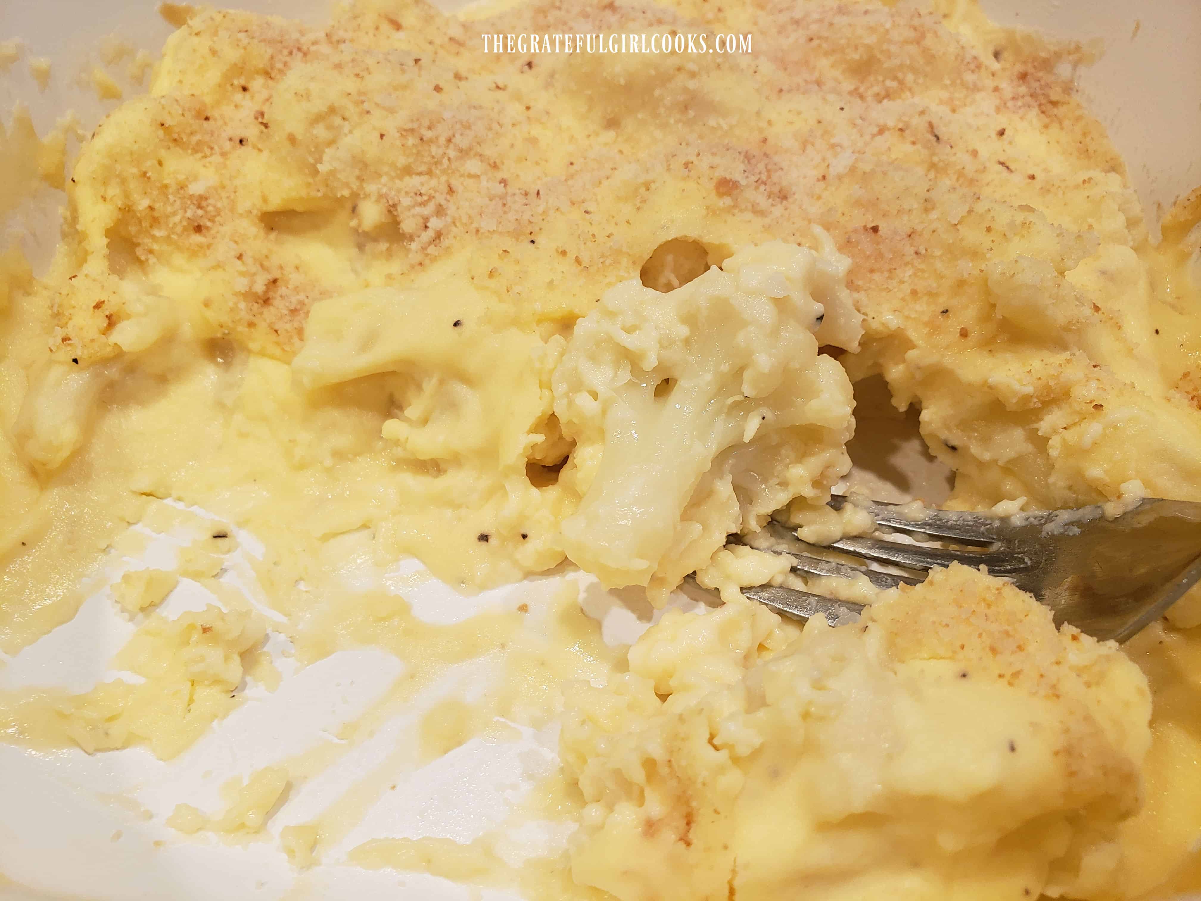 A fork with a bite of cauliflower au gratin, ready to eat!