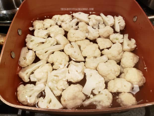 Cauliflower florets are cooked in boiling, salted water until just barely tender.