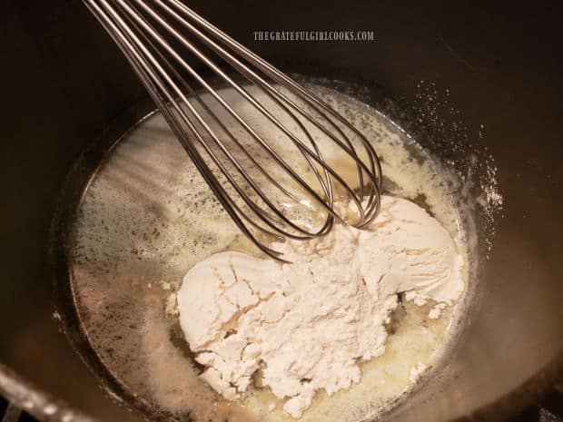 Flour is whisked into melted butter, to begin making a cheese sauce.