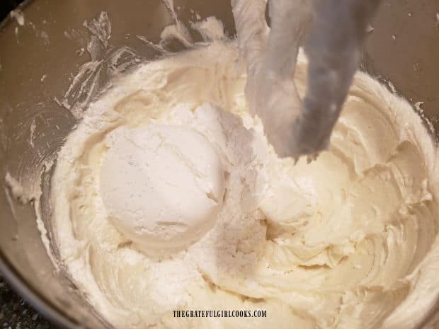 More powdered sugar is mixed into Grandma's fluffy white frosting to finish.