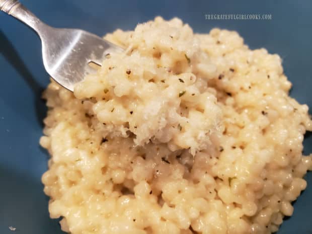 A fork holding a bite of Italian Parmesan Pearl Couscous.