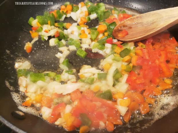 Bell peppers, carrots, onions, and butter cooking in large skillet.