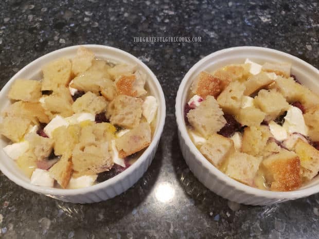 The top layer of bread cubes is pressed down into the egg filling to absorb the liquid.