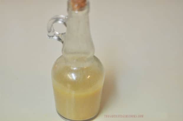 The apple cider vinaigrette is mixed, then poured into a cruet for pouring onto salad.