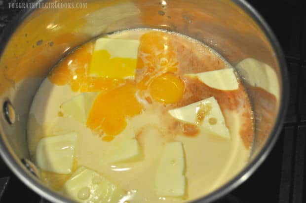 Evaporated milk, sugar, butter, egg yolks and vanilla cook in a saucepan.