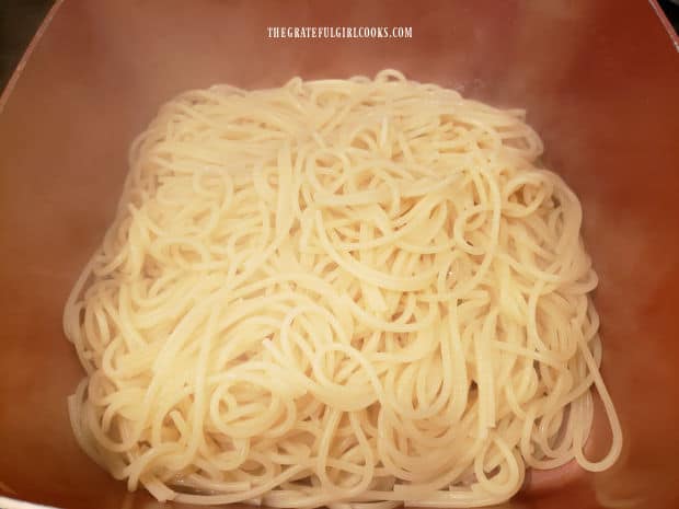 The pasta is drained and immediately placed back into the cooking pan.