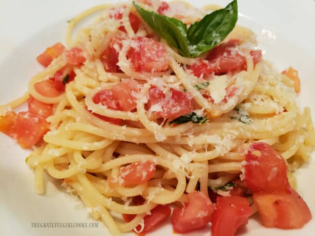A serving of easy tomato basil pasta in a white bowl is garnished and ready to enjoy!