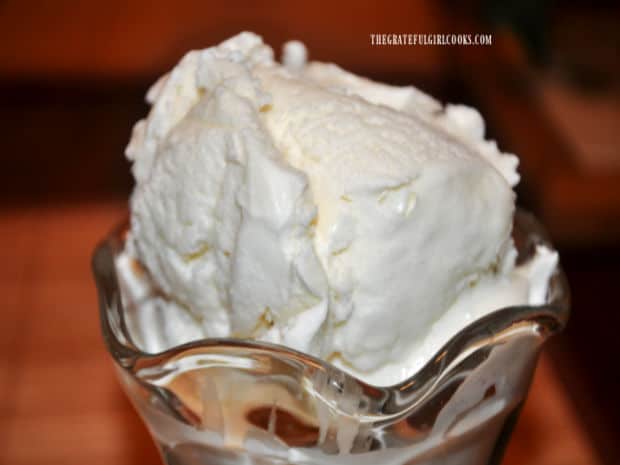 A scoop of homemade vanilla ice cream in a glass dish.