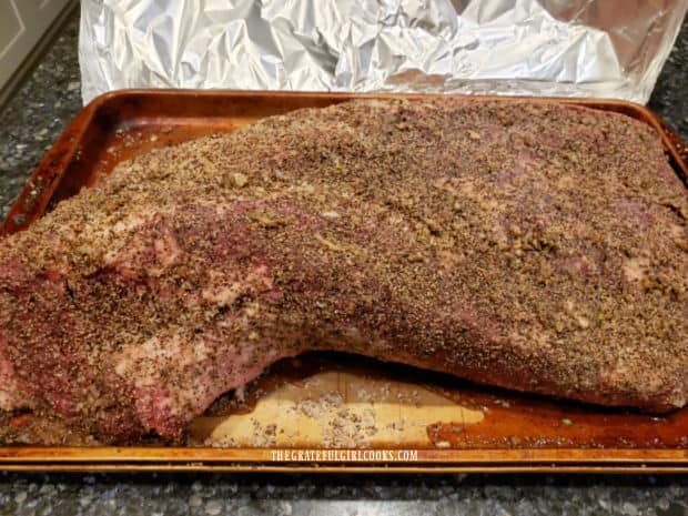 Covered in spice rub, the beef brisket is ready to put on the smoker grill.