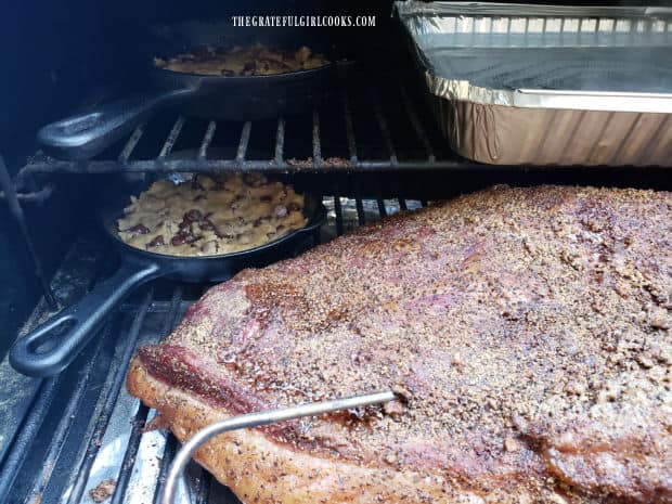 The smoked brisket of beef is cooked for several hours uncovered on the smoker grill.