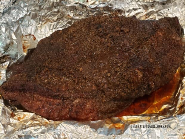 The smoked brisket of beef is unwrapped and rests for awhile before slicing.