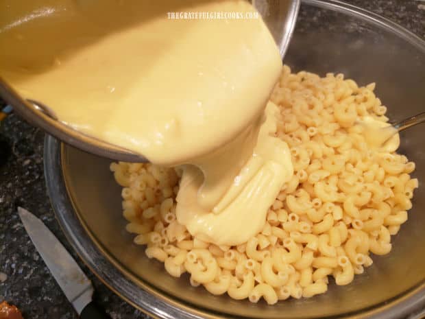 Cheese sauce is added to the cooked pasta, and stirred until combined.