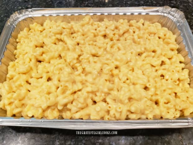 Macaroni and cheese is placed into a greased or buttered baking pan.