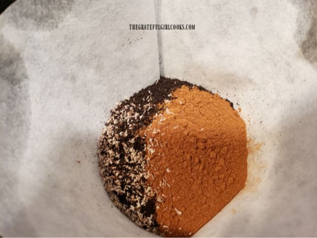 Coffee grounds, cinnamon and nutmeg are brewed in a drip coffeemaker.