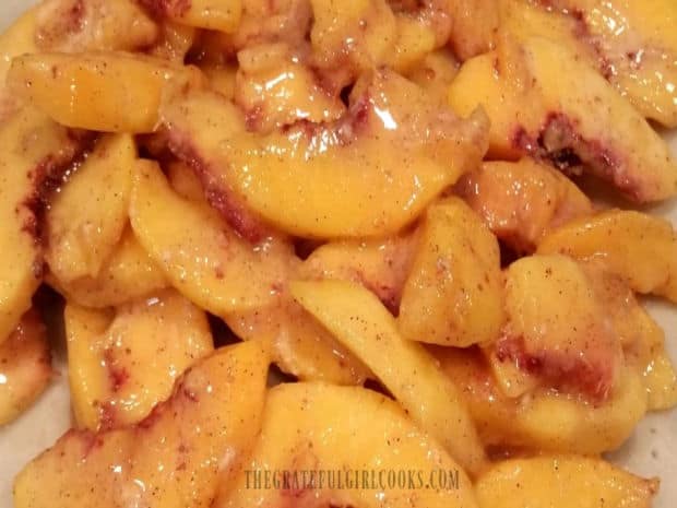 Sliced peaches are combined with sugar, flour, cinnamon and lemon juice to make the pie filling.