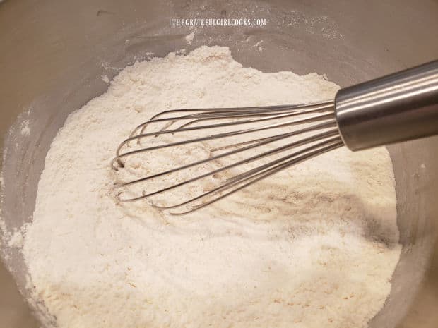 Dry pancake batter ingredients are whisked together in a large bowl.