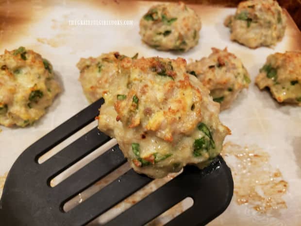 A close up of one of the Italian Chicken Parmesan Meatballs on a spatula.