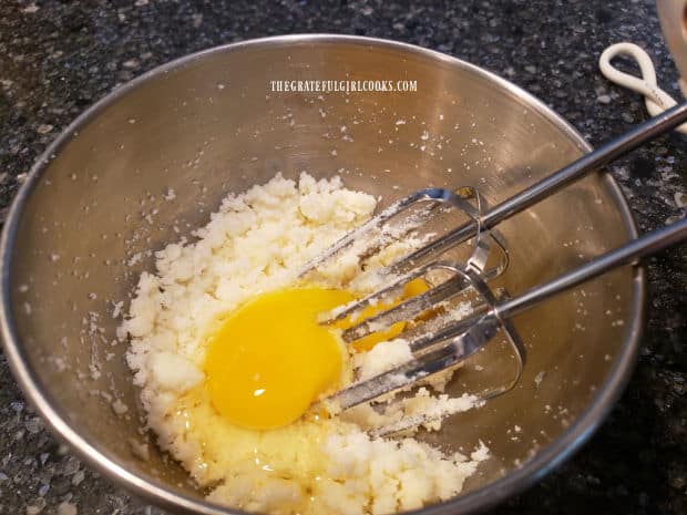 An egg is beaten into the creamed butter and sugar.