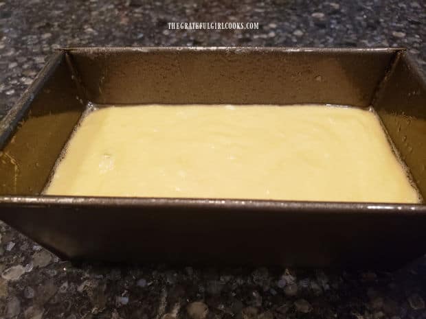 The batter for the mini-loaf pound cake is poured into a greased loaf pan, for baking.