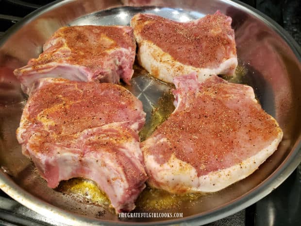 Seasoned pork chops are browned in a skillet before putting them on the smoker.