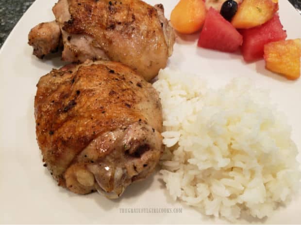 The grilled chicken thighs have a nice smoky flavor and are served with fruit salad and rice.
