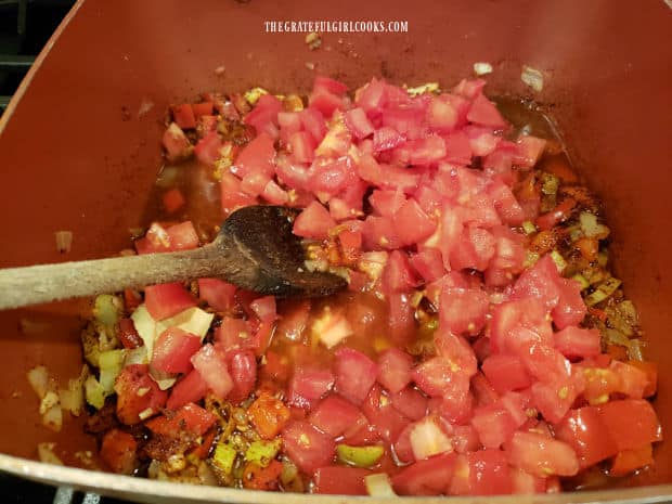 Chopped fresh tomatoes are added to the saucepan with cooked veggies and spices.