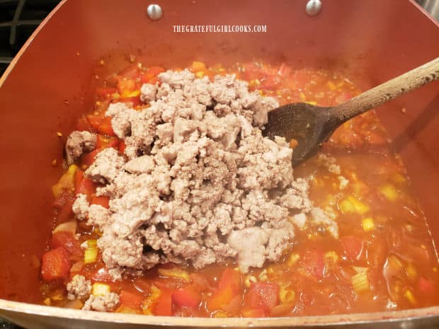 Cooked ground turkey is added to the chili.