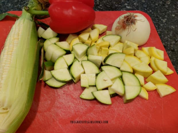 Corn, red bell pepper, onion, and squash will be prepped for this veggie dish.