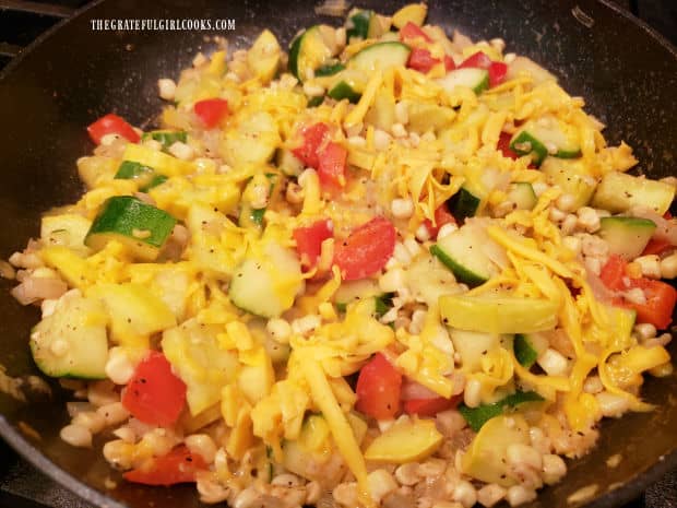 Grated cheese is sprinkled on the TexMex Zucchini Squash Skillet before serving.