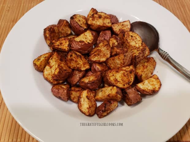 A white bowl, full of air fryer Cajun spuds, ready to eat!