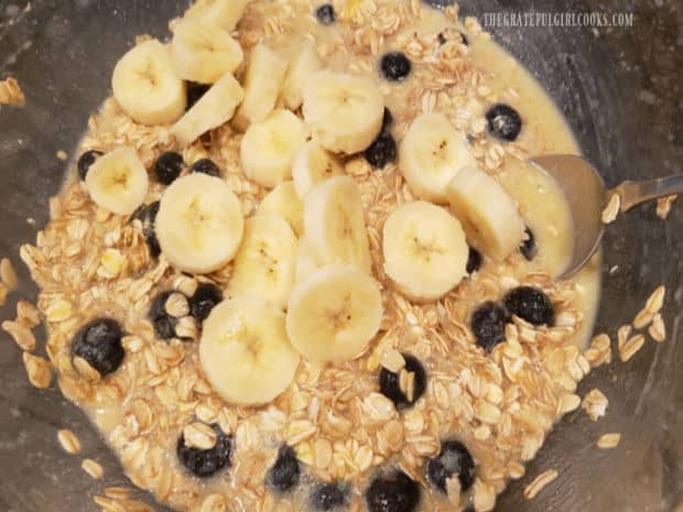 Sliced bananas are gently stirred into the blueberry banana baked oatmeal mixture.