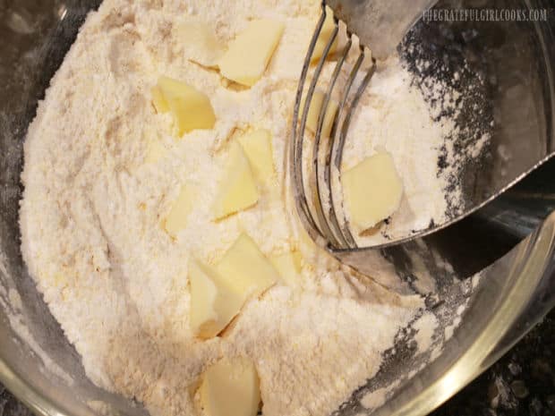 Cold chunks of butter are cut into the dry ingredients with a pastry blender, for the biscuits.