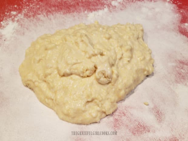  The sticky biscuit batter is placed on a floured surface for kneading.