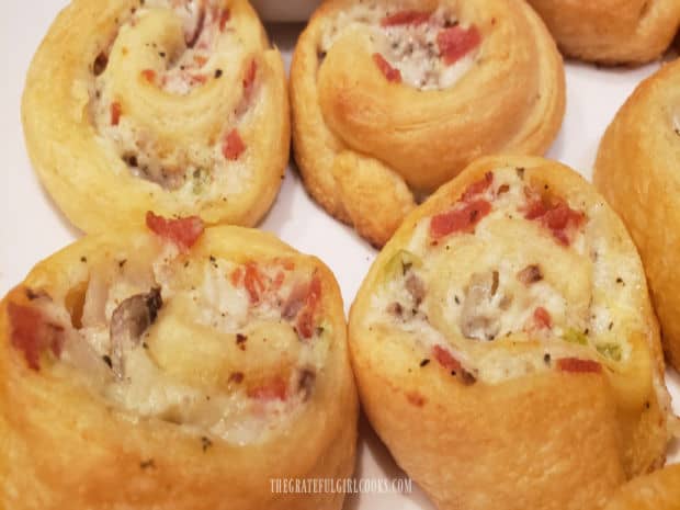 Close up photo of four of the cheesy calzone pinwheels, ready to eat.